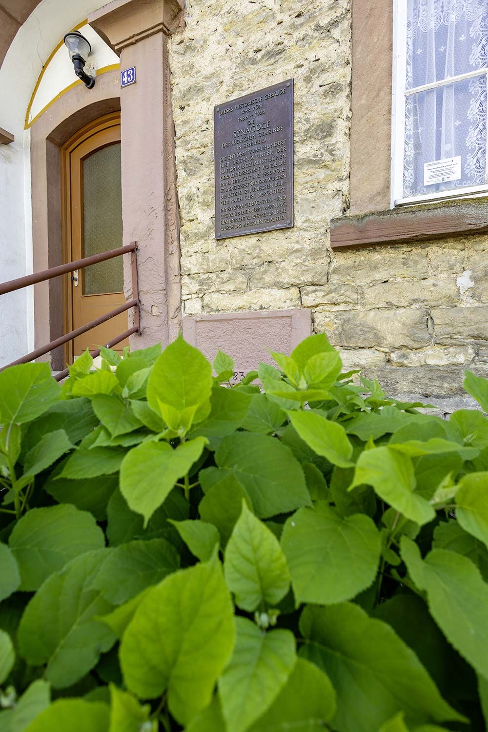 Der Aussenbereich der ehemaligen Synagoge in Sennfeld mit Blick auf die Gedenkplakette